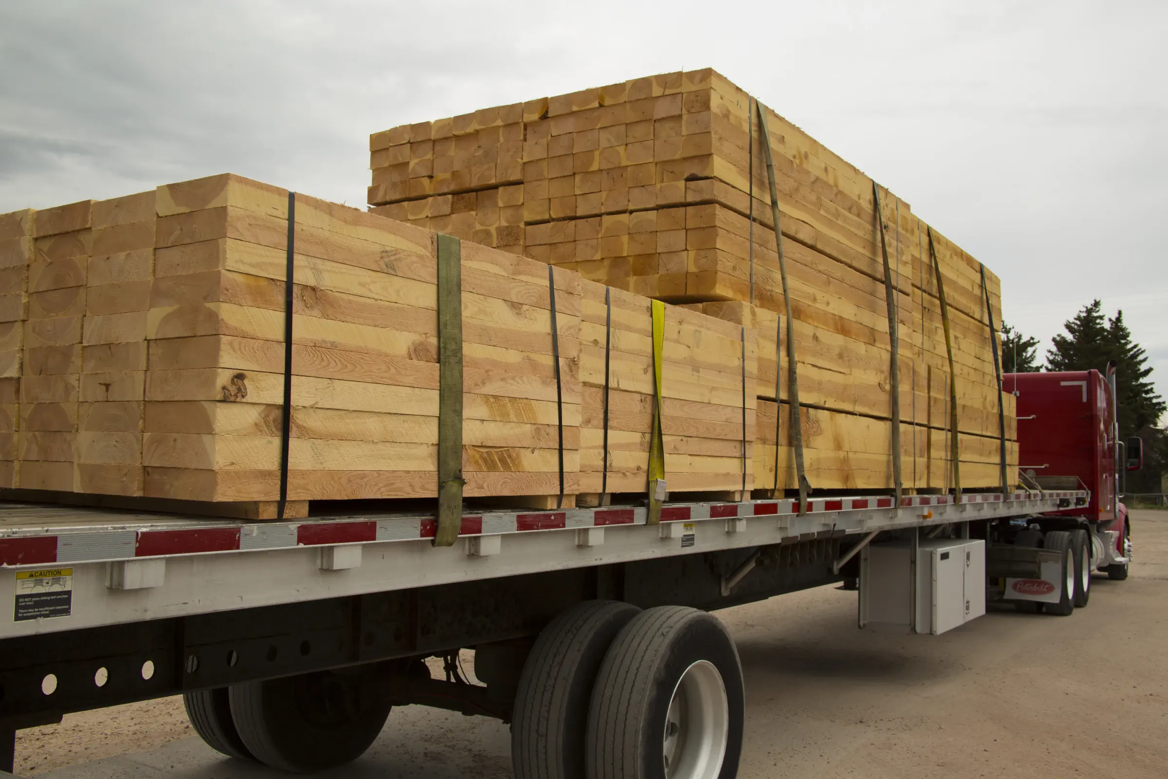 A flatbed truck loaded with bundled lumber for delivery